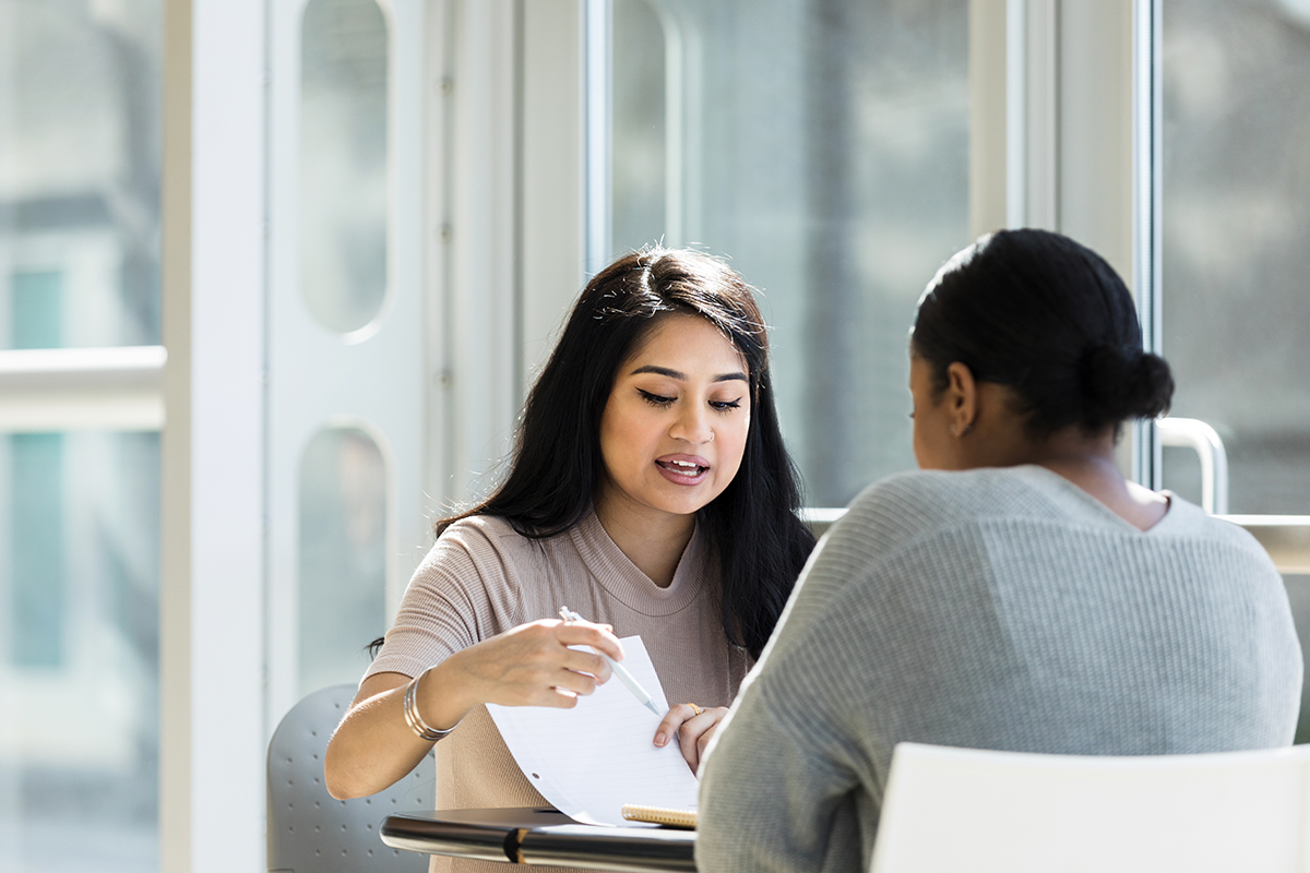 Two women collaborating across a table